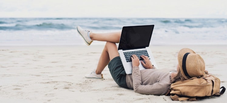 digital nomad working from the beach